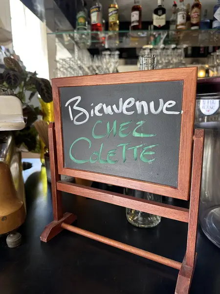 Ardoise Bienvenue Chez Colette posée devant le bar